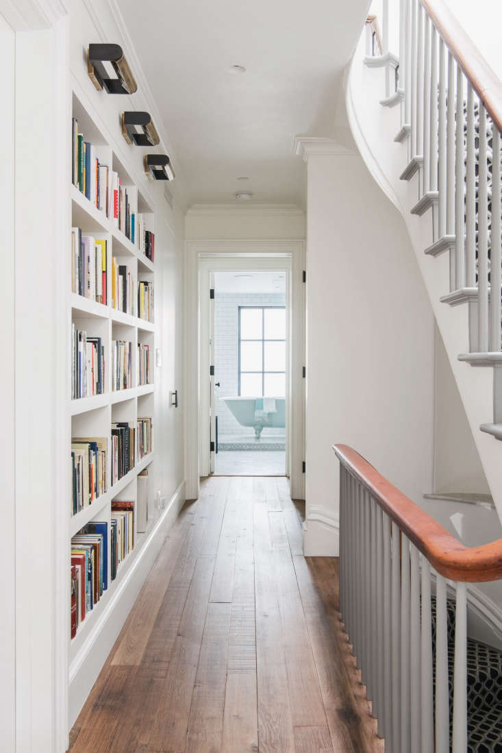 A built-in bookcase beautifully maximizes storage space in this narrow hallway. See An Unfussy Brooklyn Townhouse Remodel from Architect Elizabeth Roberts. Photograph by Dustin Aksland.
