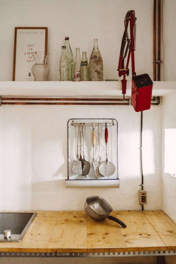 A vintage enamelware utensil rack in their Sa Calma Annex kitchen. (See Design Sleuth: Vintage Kitchen Utensil Racks from France.)